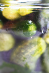 glass jar with a pickled cucumbers. gherkins cucumbers background.
