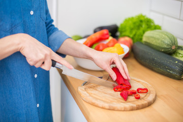 Woman slicing paprika at a kitchen 