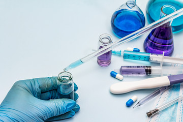 Fototapeta premium Female hand holds a test tube. Laboratory studies of coronavirus. Worldwide pandemic COVID-19, 2019-nCoV, SARS-CoV-2