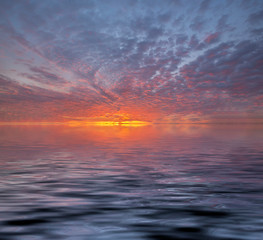 Fototapeta na wymiar View of sunset into the ocean with twilight sky. Fiery orange sunset sky. Beautiful sky