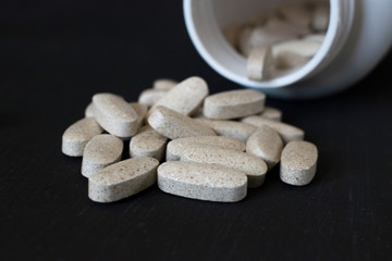 Natural vitamins in tablets on a black background