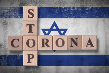 Obraz premium Flag of Israel with wooden cubes spelling STOP CORONA on it. 2019 - 2020 Novel Coronavirus (2019-nCoV) concept art, for an outbreak occurs in Israel.