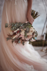 wedding bouquet with protea on pink wedding dress background
