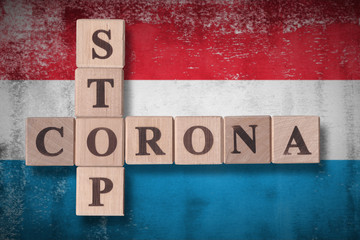 Flag of Luxembourg with wooden cubes spelling STOP CORONA on it. 2019 - 2020 Novel Coronavirus (2019-nCoV) concept art, for an outbreak occurs in Luxembourg.