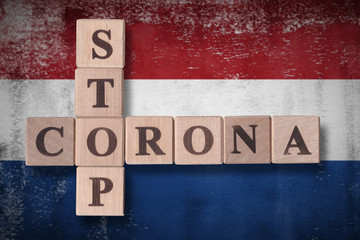 Flag of Netherlands with wooden cubes spelling STOP CORONA on it. 2019 - 2020 Novel Coronavirus (2019-nCoV) concept art, for an outbreak occurs in Netherlands.
