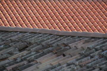 Old and new roof tiles of a building