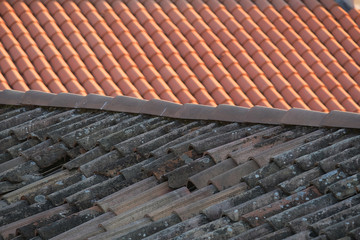 Old and new roof tiles of a building