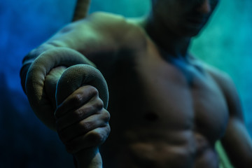 Muscular male circus artist with Cord Lisse on black an smoked background © Hladchenko Viktor