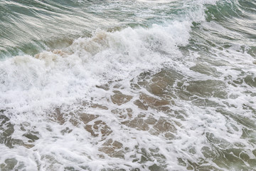 Beach texture. Golden sand and sea foam pattern. Beach background with copy space. Abstract sea background. Ocean waves close-up.
