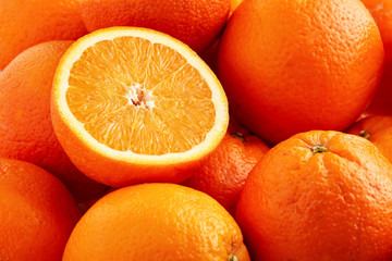 Heap of fresh oranges with one half slice
