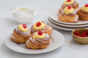 Italian pastry - zeppole di San Giuseppe - baked cream puffs made from choux pastry, filled and decorated with custard cream and cherry. It is eaten to celebrate Saint Joseph's Day.