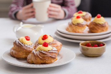 Italian pastry - zeppole di San Giuseppe - baked cream puffs made from choux pastry, filled and decorated with custard cream and cherry. Eaten to celebrate Saint Joseph's Day.