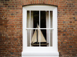 Little boat decorated in white framed window.