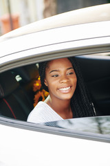 Beautiful young Black woman sitting on backseat of car when riding to work in the morning in taxi