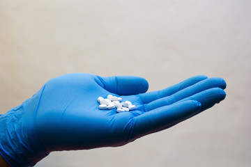 Hand in medical glove takes pill - choice medicine, coronavirus, covid19