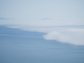 Fototapeta premium Blue background of clouds and sea. View from above. Meteorological phenomena