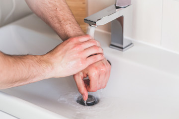 Hand washing with soap in bathroom to prevent contamination, close up