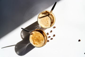 Cold coffee – latte, cappuccino or dalgona. Summer trendy drink with whipped milk, top view