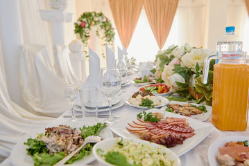 Table served for wedding banquet in restaurant. Table set with plates, white serviettes and cutlery on table, copy space. Place setting at wedding reception