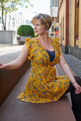 young woman in a yellow dress sitting