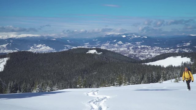 Winter sports and recreation hiking concept. Man backpacker tourist walking snow landscape. Carpathian mountain range. 4K