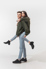 Youth. Trendy fashionable couple isolated on white studio background. Caucasian woman and man posing in basic minimal unisex clothes. Concept of relations, fashion, beauty, love. Inclusive.