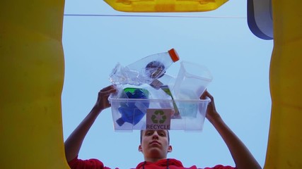 Zero waste. Slow Motion of Young Teenager throwing used Bottles into bin and Recycling Plastic. Plastic is sorted and kept separated from other waste. Collection container with recycling symbol.