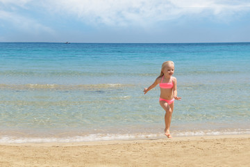 Fototapeta na wymiar Little girl at the beach. Summer vacation concept