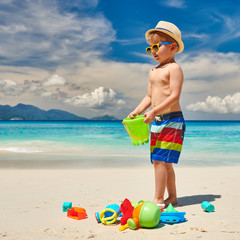 Three year old toddler playing on beach