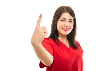 Portrait of beautiful young doctor wearing scrubs showing number one