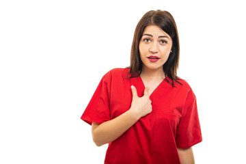 Portrait of beautiful doctor wearing scrubs using showing herself