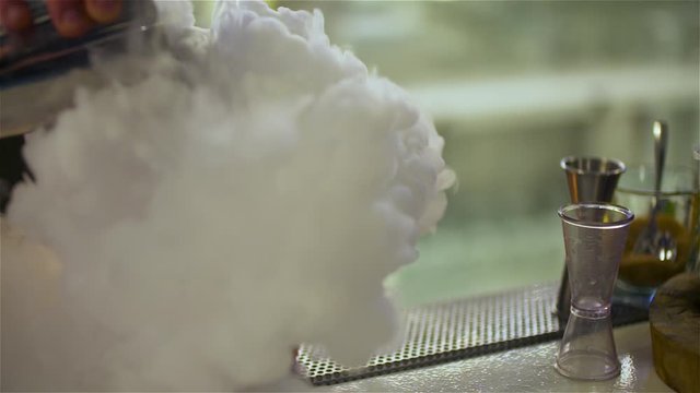 bartender preparing dry ice drink at club