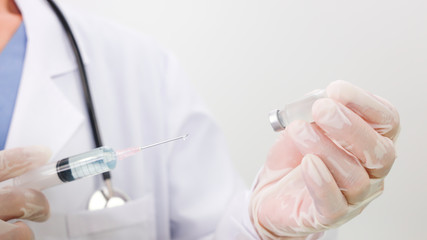 Selective focus of Doctor which his Hand holding syringe and vaccine,corona virus concept