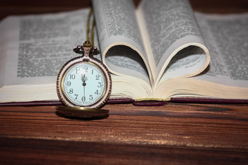 a pocket watch with book background