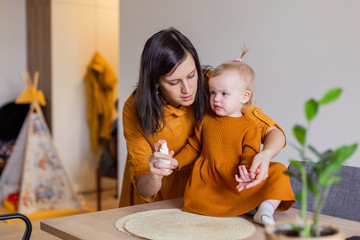 Hand disinfection with an antiseptic mom helps baby. Antibacterial spray sanitation of surfaces...