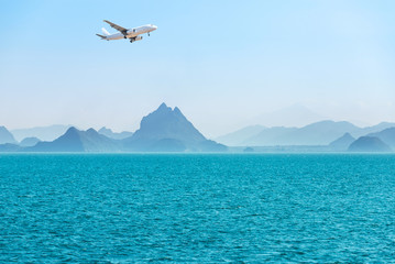landscape view white passenger airplane landing above group of small island in tropical turquoise sea travel destinations concept.