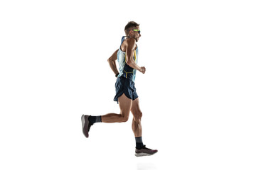 Triathlon male athlete running isolated on white studio background. Caucasian fit jogger, triathlete training wearing sports equipment. Concept of healthy lifestyle, sport, action, motion. Side view.