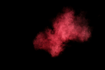 Red and pink powder explosion on black background. Colored powder cloud. Colorful dust explode. Paint Holi.