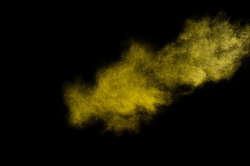 Fototapeta na wymiar Yellow powder explosion on black background. Colored powder cloud. Colorful dust explode. Paint Holi.