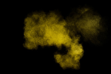 Yellow powder explosion on black background. Colored powder cloud. Colorful dust explode. Paint  Holi.