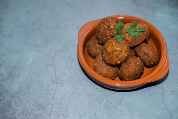 Falafel isolated on a clay bowl in concrete background. Healthy and vegan meal.