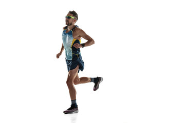 Triathlon male athlete running isolated on white studio background. Caucasian fit jogger,...