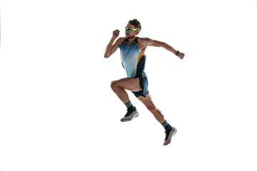 Triathlon male athlete running isolated on white studio background. Caucasian fit jogger, triathlete training wearing sports equipment. Concept of healthy lifestyle, sport, action, motion. In jump.