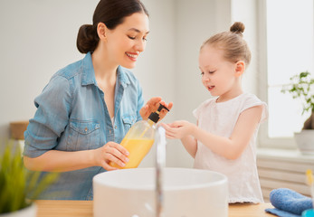 girl and her mother are washing hands