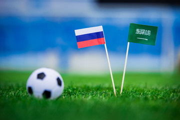National flag of Russia and Saudi Arabia on Football pitch. Football ball on green grass