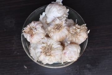 One whole aromatic white garlic isolated on black background