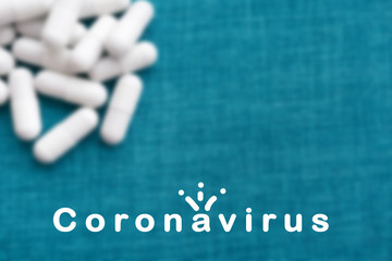  Virus inscription in white on a blue background. Crown icon. Against the background of white capsules in defocus. The concept of the treatment of dangerous deadly coronavirus. Free place