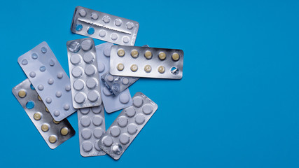 Tablets. Many tablets are on a blue background,  Drugs and pills prescription background. Pharmaceutical preparation.