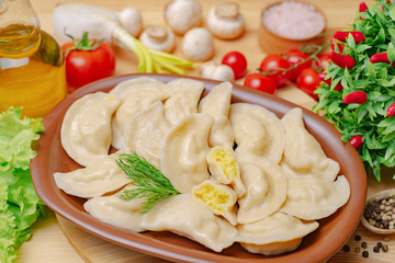Dumplings on a wooden board with potato