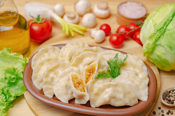 Dumplings on a wooden board with cabbage